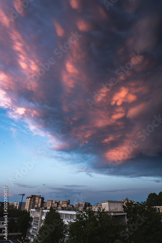 Mammatus clouds over city at dusk