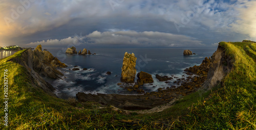 Fotografía panorámica nocturna de la Costa Quebrada en Liencres, Cantabria, España, que muestra el espectacular litoral rocoso del mar Cantábrico.