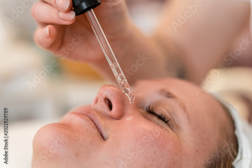 Foto Woman receiving a facial serum treatment at a spa