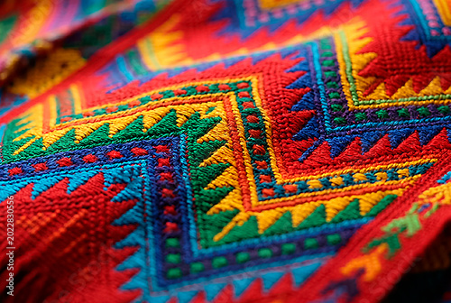 Vibrant Mayan huipil textile design, handmade folklore fabric texture background.