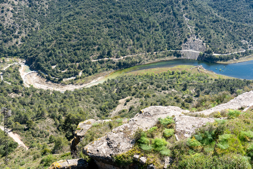Foto A breathtaking bird's-eye view from a rocky precipice overlooking a winding river, mountain roads, and dense Mediterranean forest in Catalonia, Spain