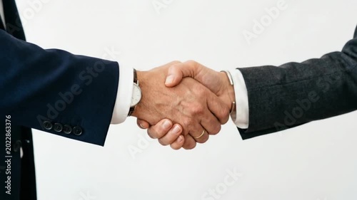 A professional handshake between two businessmen in suits symbolizes a successful corporate agreement, teamwork, and a strong partnership