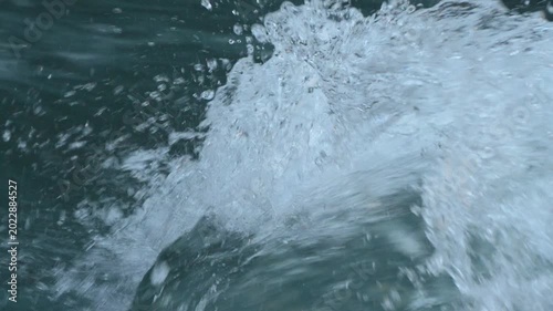 Ocean water splashing and creating white foam at sea during a bright day showing high energy and fresh texture in 120fps 4K Slow Motion