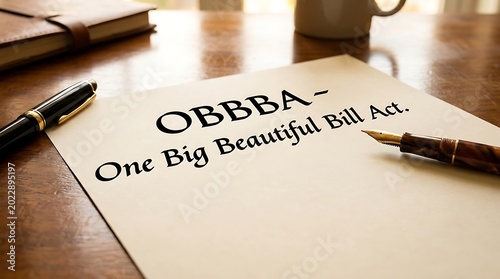 A close-up view of an OBBBA bill on a wooden table with a pen