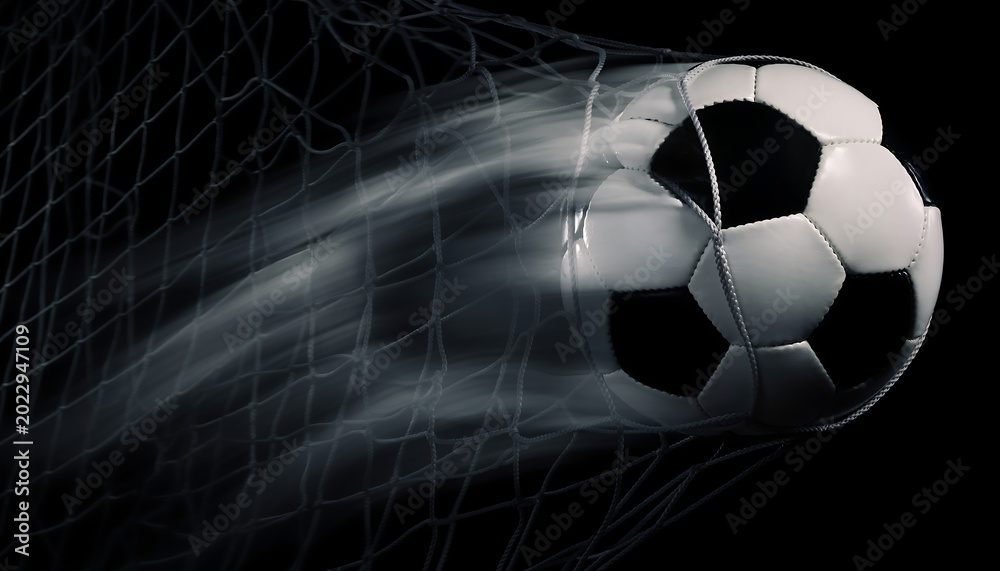 Fototapeta premium High speed soccer ball hitting the net with dramatic motion blur on black background