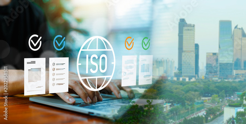 Foto Businessman working on laptop with ISO certification icon and city background