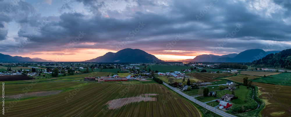 Fototapeta premium Sunset Panorama Over Fraser Valley Farmland With Mountains in British Columbia, Canada