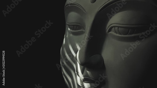 Rays of light play on the cheek of the Buddha statue
