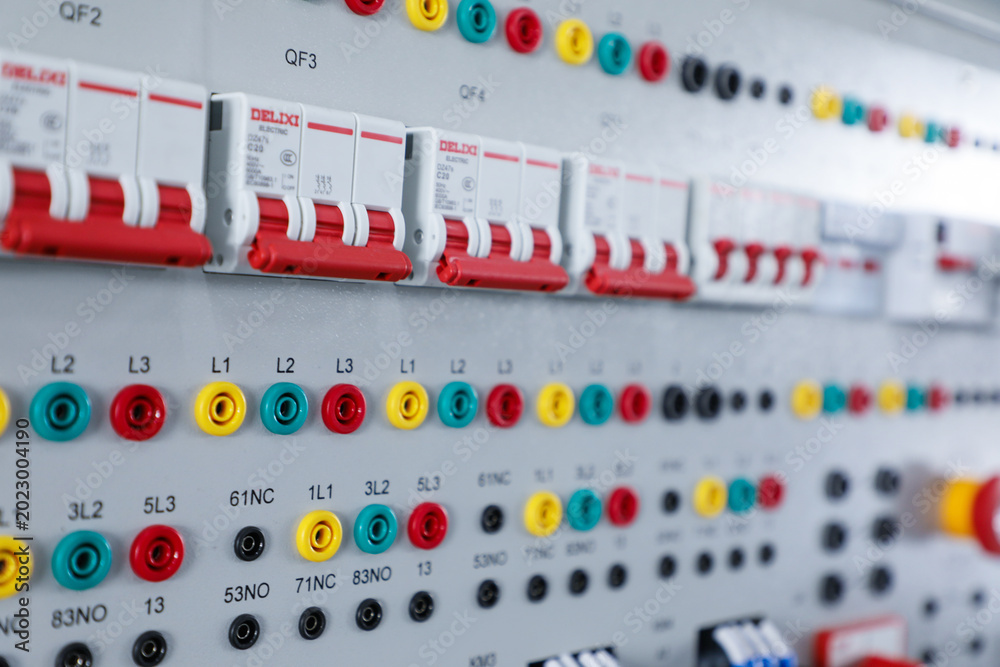 Fototapeta premium Close Up of Electrical Control Panel with Circuit Breakers and Colored Terminals