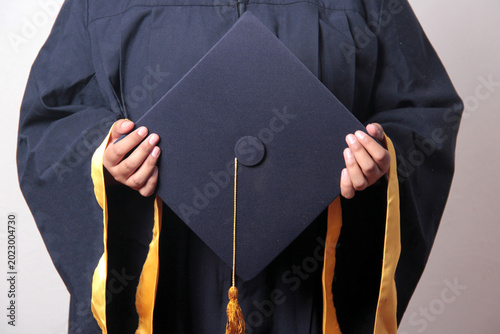 Photos Young, dark-haired Latina woman dressed in a cap and gown is happy and excited t