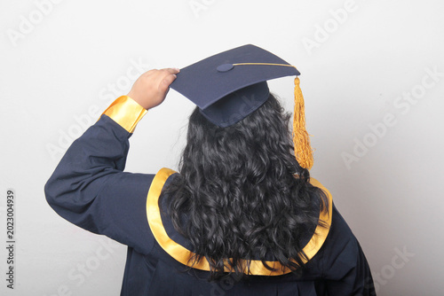 Tableau sur toile Young, dark-haired Latina woman dressed in a cap and gown is happy and excited t
