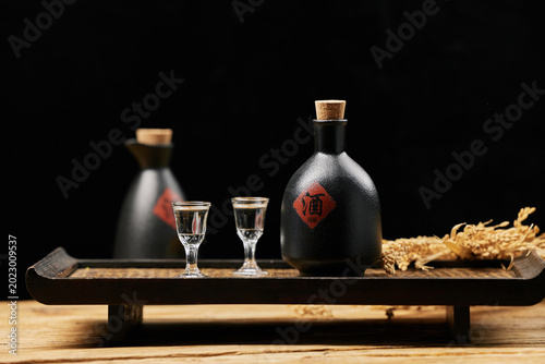 Bild auf Leinwand Traditional Chinese Baijiu Bottles and Glasses on Wooden Tray
