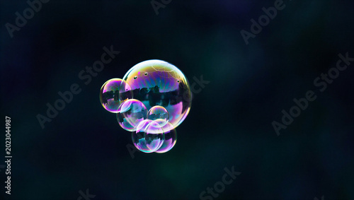 Cuadro en lienzo Iridescent soap bubble floating against a dark background with floating