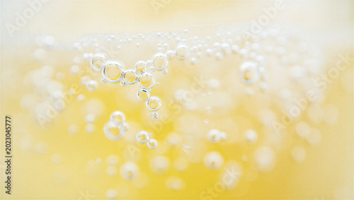 Quadro su tela Macro close up of bubbles rising in carbonated yellow drink with carbonated