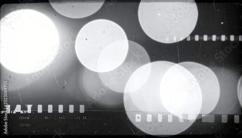 Filmstrip with glowing white bokeh lights on a dark background with scratches and texture