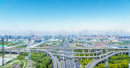 Fotografie Aerial view of urban highway interchange with river, industry, and city skyline