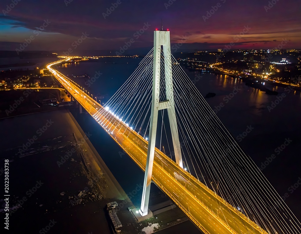 Fototapeta premium Cable-stayed bridge over water at night.