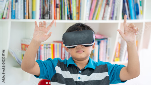 Young Boy Using Virtual Reality Headset for Modern Education in Library