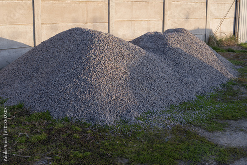 Cuadro en lienzo Gray gravel and crushed stone heaps stored outdoors near industrial wall