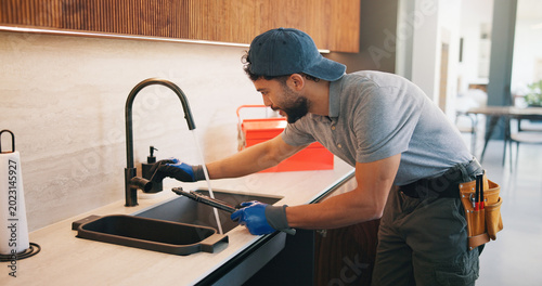 Foto Repair, check or plumber in kitchen with tools, tap testing or sewer review in system maintenance