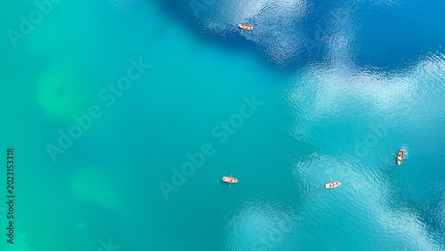 Quadro su tela Serene boats gliding across vibrant turquoise waters under a clear sky at midday