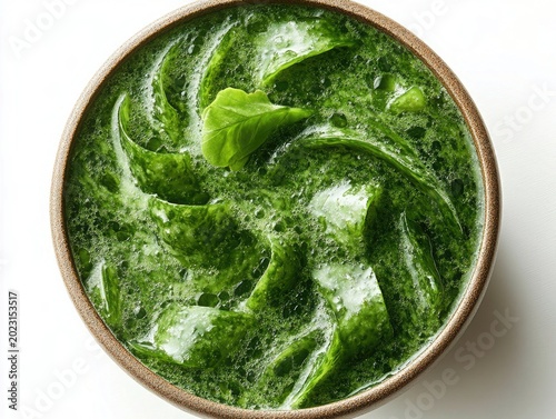 Creamy green spinach soup in a brown bowl, top view with spinach garnish. Healthy food images for blogs or websites to promote delicious meals.
