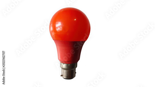 Bright orange light bulb glowing on white