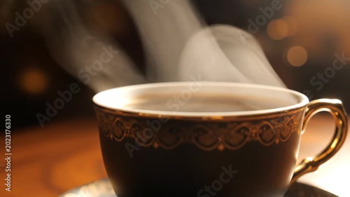Steaming hot coffee in a decorative cup with golden accents, close-up