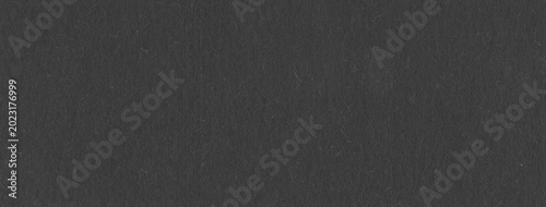 Soft black paper texture with matte finish and visible fibers ideal for minimalist backgrounds and elegant designs.