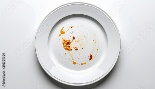 Empty dirty white plate with food leftovers and sauce stains. 
