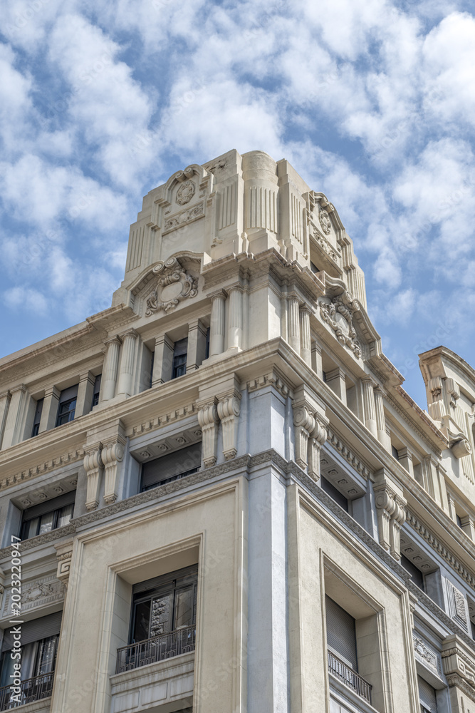 Fototapeta premium Building Facade with Ornate Stone Carvings, Barcelona, Neoclassical Pillars, Historic European Architecture