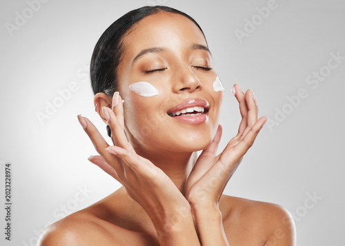 Bilde på lerret Happy, woman and skincare in studio with face cream, hyaluronic acid or hydration benefits for beauty
