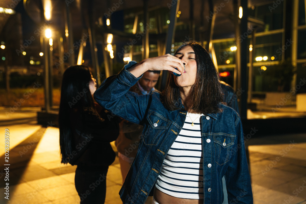 Fototapeta premium Diverse friends enjoying nightlife together, celebrating with drinks and having fun in an urban setting