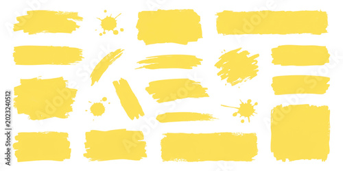 Set of yellow paint brush strokes and ink splatters for creative design backgrounds and artistic graphic elements