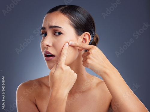 Quadro su tela Portrait, woman and popping pimple in studio for skincare, acne breakout and skin irritation