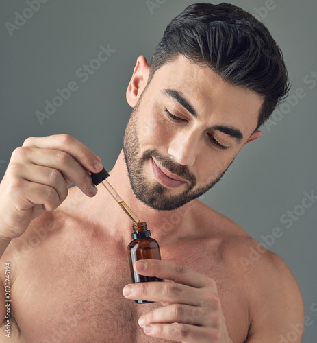 Fotografie Beauty, dropper and beard oil with man in studio for skincare, cosmetics and dermatology
