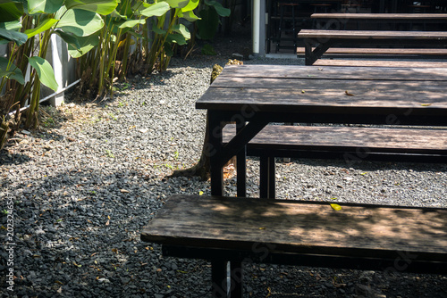 Konstfotografi close up of rustic wooden benches and tables in an outdoor cafe garden with grav