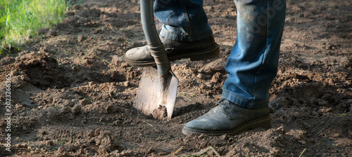 Man's feet with a shovel