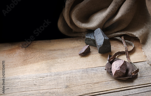 An antique leather sling lies on wooden desk