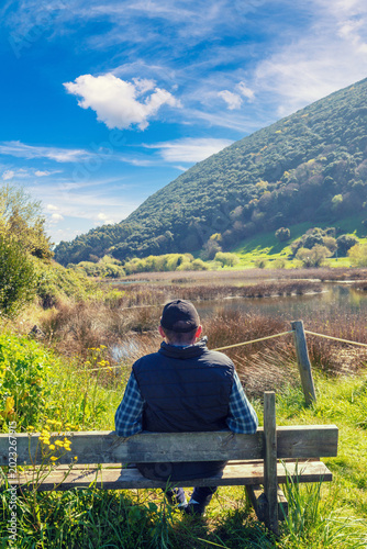A man tourist looks at the picturesque wildlife. Natural Reserve (Natural Resources) Marisma de Joyel. Cantabria, Spain, Europe