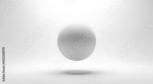 A single shiny metallic sphere sitting on a flat surface in a studio setting with soft lighting