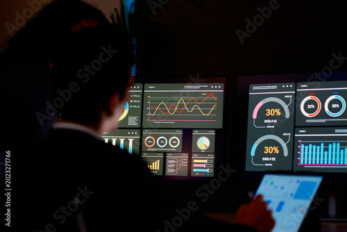 IT or Networker team working in dark room for monitor traffic graphic information in office.