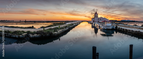 Foto windmill in the salt flats at sunset, Stagnone Nature Reserve, Marsala , Trapani
