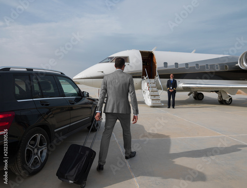Фотография Middle Eastern business team boarding private jet at airport tarmac with luggage