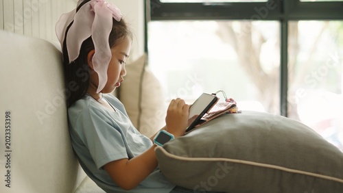 Photos Young girl concentrating on smartphone, engaging with mobile game technology