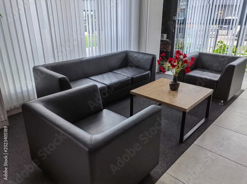 Fotografía Modern lounge area with black leather sofas and coffee table