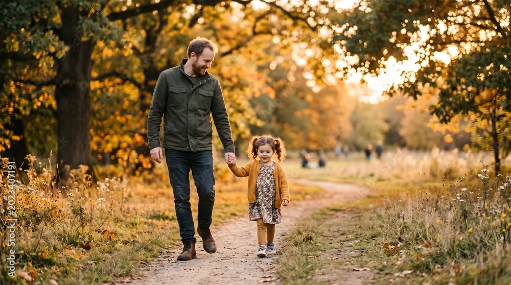 Fototapeta premium Father and Daughter Walking in Autumn Park Together.