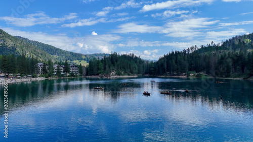 Konstfotografi Serene reflection of mountains and clouds above a peaceful lake at midday with b