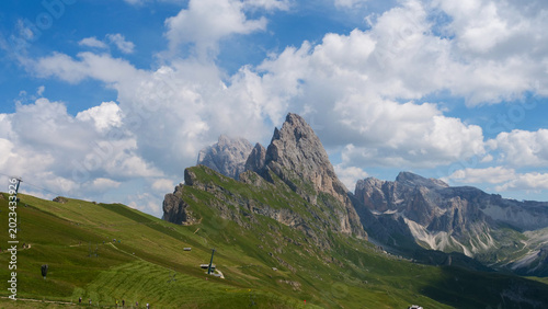 Fotografie Majestic mountain peaks rise dramatically against a vibrant sky in the Dolomites