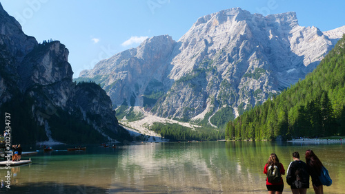 Bild auf Leinwand Serene hikers revel in nature's beauty at a pristine lake surrounded by majestic